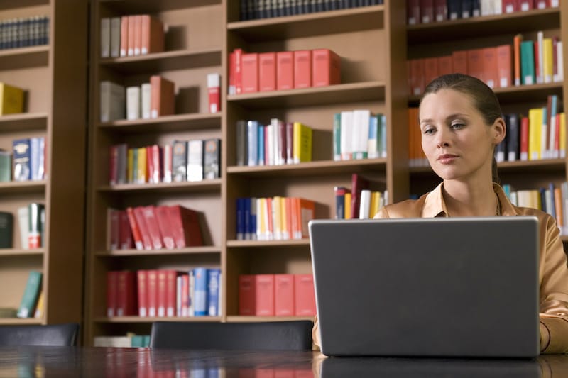 professional on a laptop in a library