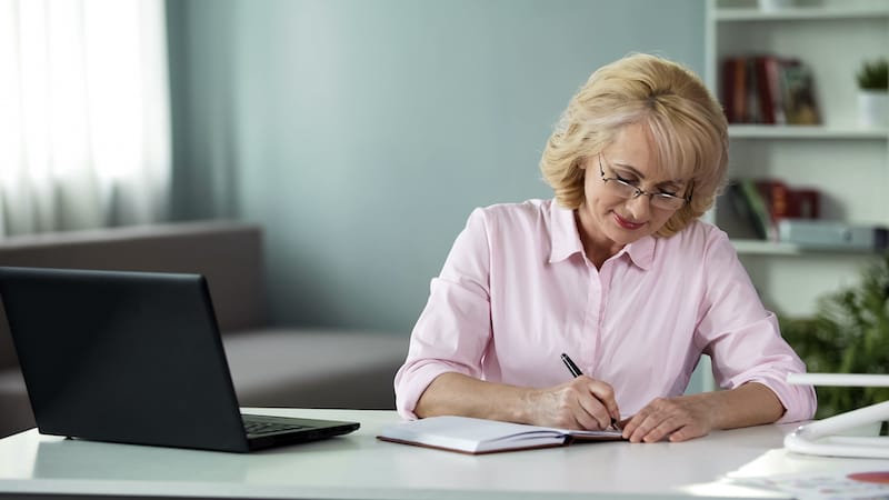 Business woman writing down to notebook plan for near future, freelancer work