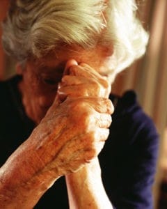 woman holding fists to face